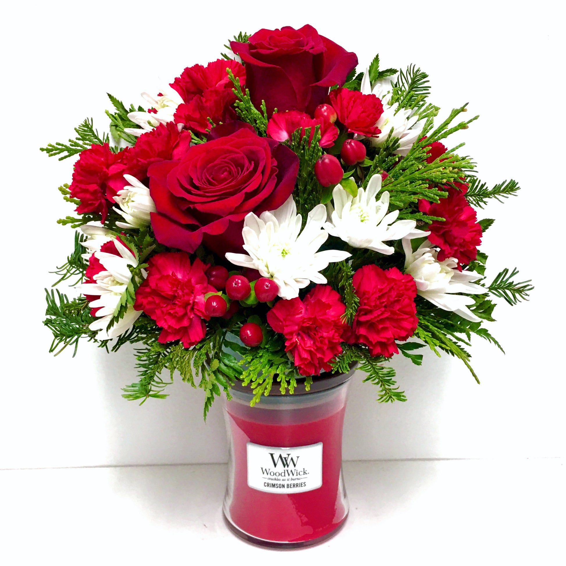 Bouquet of red and white flowers in a WoodWick candle container on a white background in Miami Beach Christmas flowers