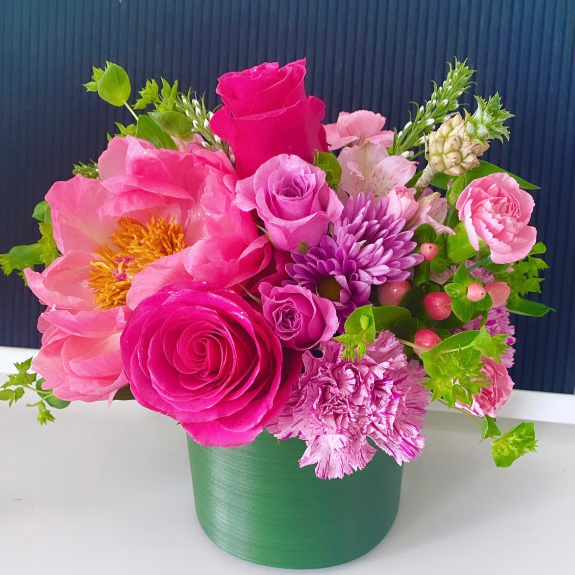 Colorful flower arrangement with roses, peonies, and pineapple accents. Floral arrangement to be delivered in Miami Beach