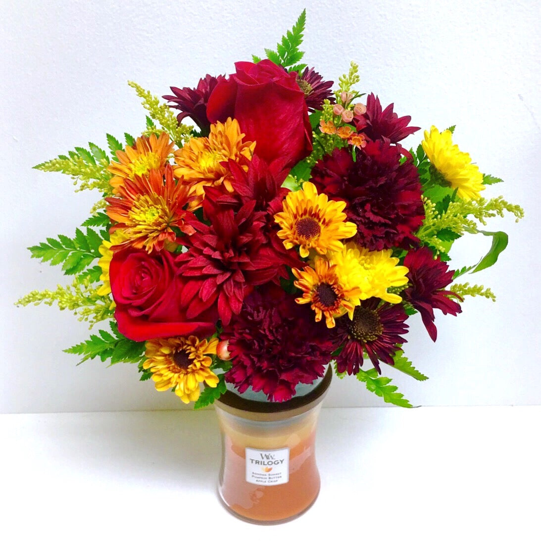 Bouquet of red and yellow flowers in a clear vase on a white background to send flowers today from Miami Beach florist