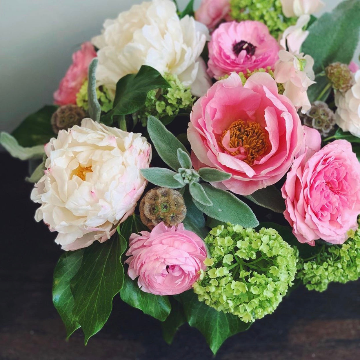 Bouquet of pink and white flowers with greenery on a dark background for flower delivery in Miami